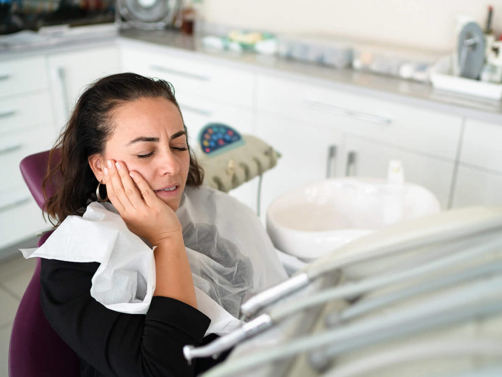 woman grabbing face in pain