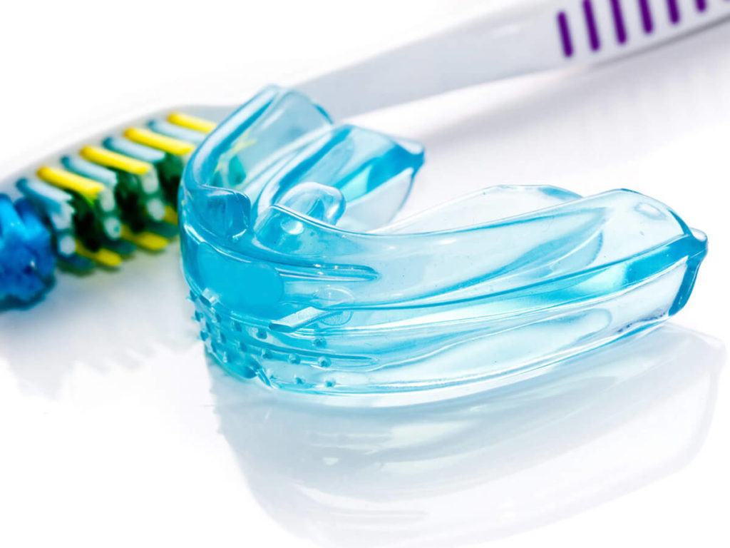 night mouth guard placed near tooth brush