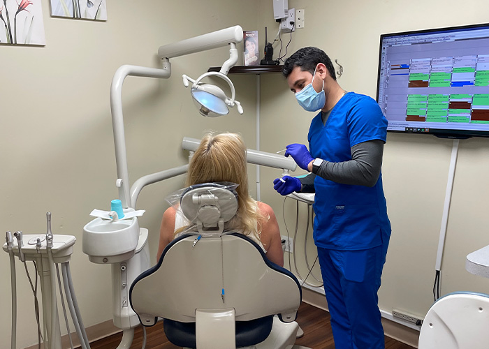 Assistant preparing dental patient for services